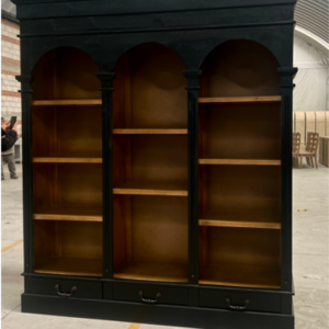 Hacienda Arch Bookshelf with black frame, warm wood interior shelves, three arched openings, and bottom storage drawers